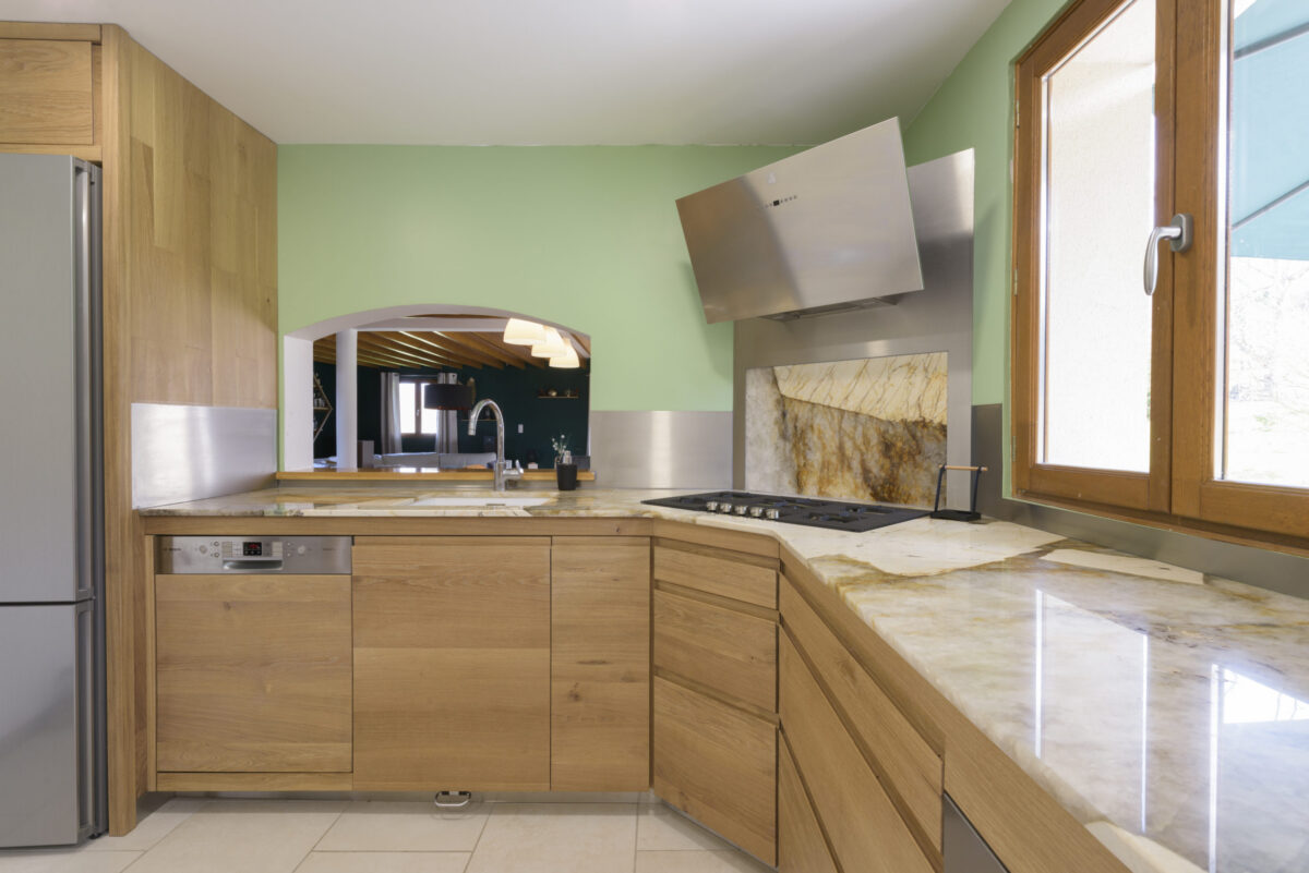 Cuisine en bois clair avec plan de travail en pierre dorée veinée