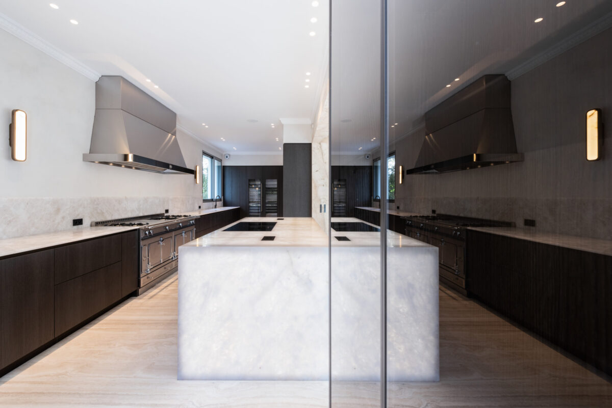 Îlot de cuisine en cristal de roche rétroéclairé entre des façades sombres