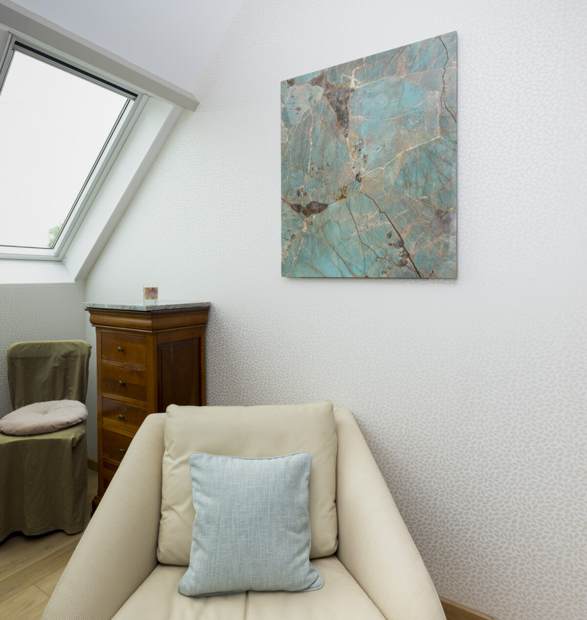 Tableau en amazonite bleu-vert accroché au mur près d'une fenêtre de toit