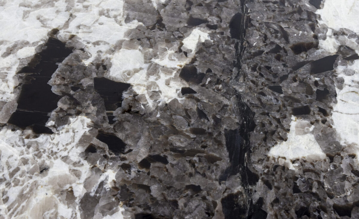 Gros plan sur le veinage d’un granit Patagonia noir aux cristaux blancs et gris