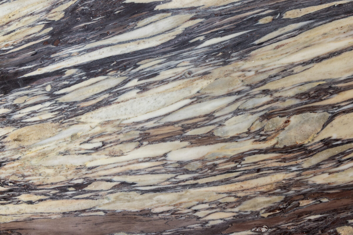 Gros plan sur un marbre Calacatta poli aux veines brunes, beiges et grenat
