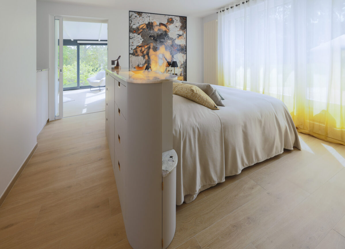 Chambre avec tête de lit en marbre veiné et baie vitrée