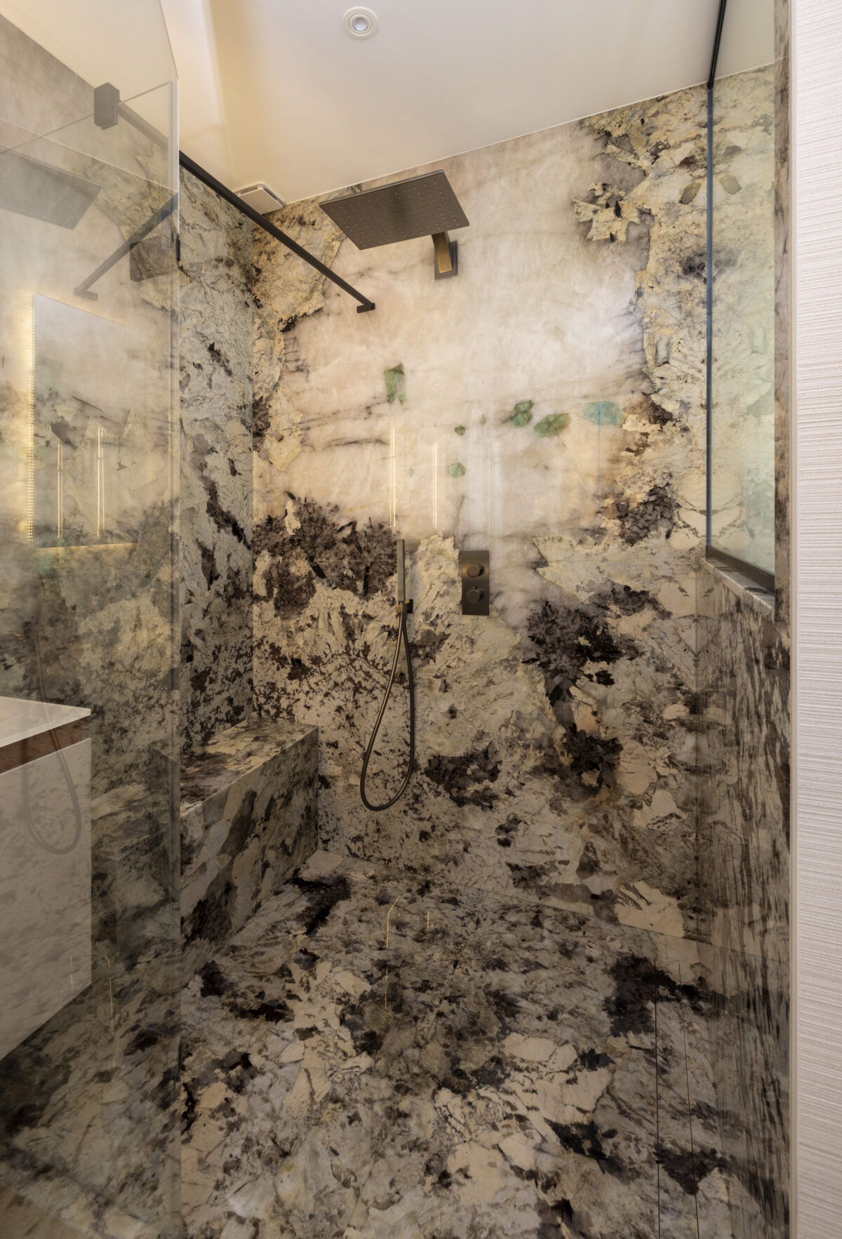 Paroi de douche en pierre translucide rétroéclairée aux motifs sombres