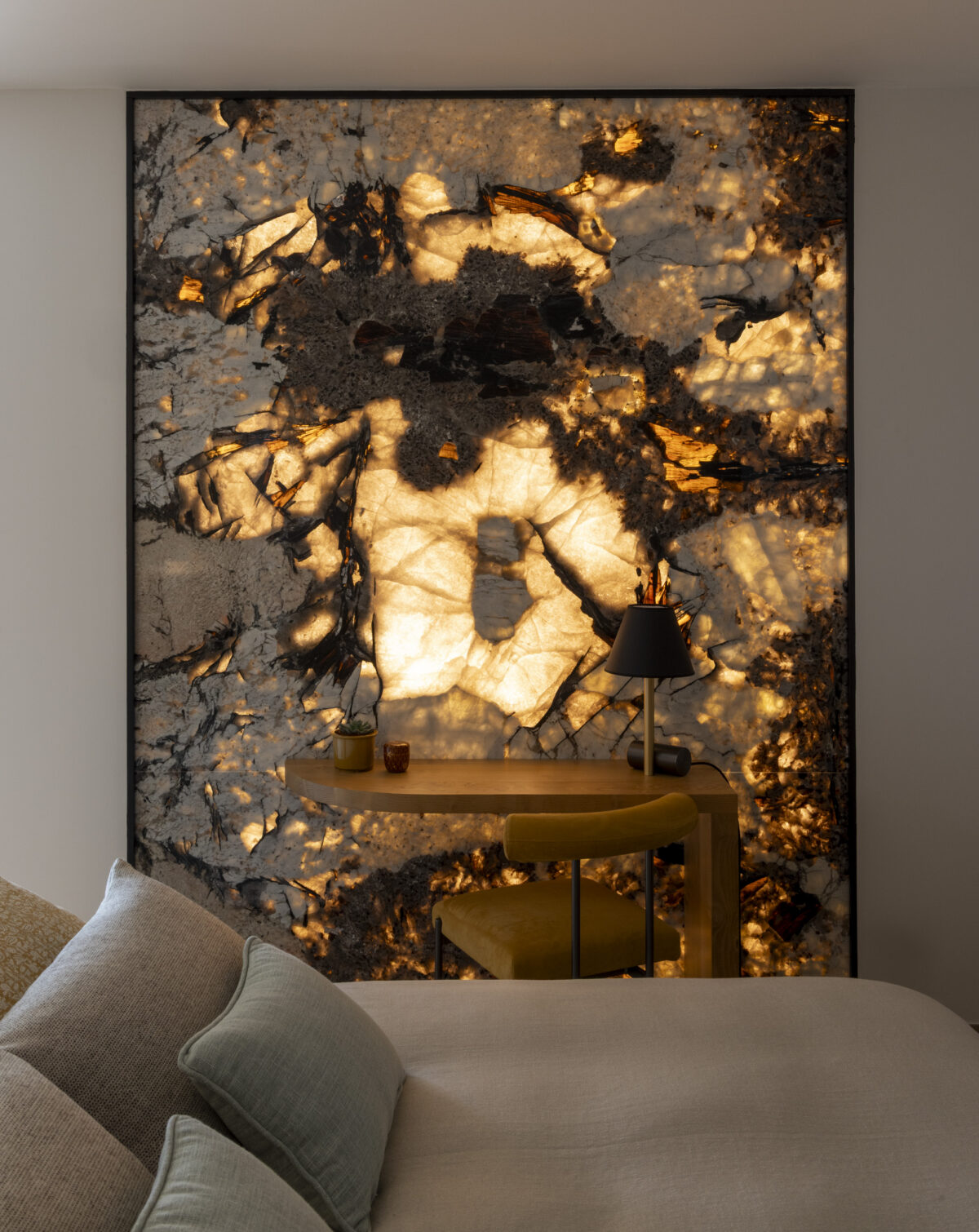 Panneau de pierre rétroéclairée aux motifs dorés dans une chambre