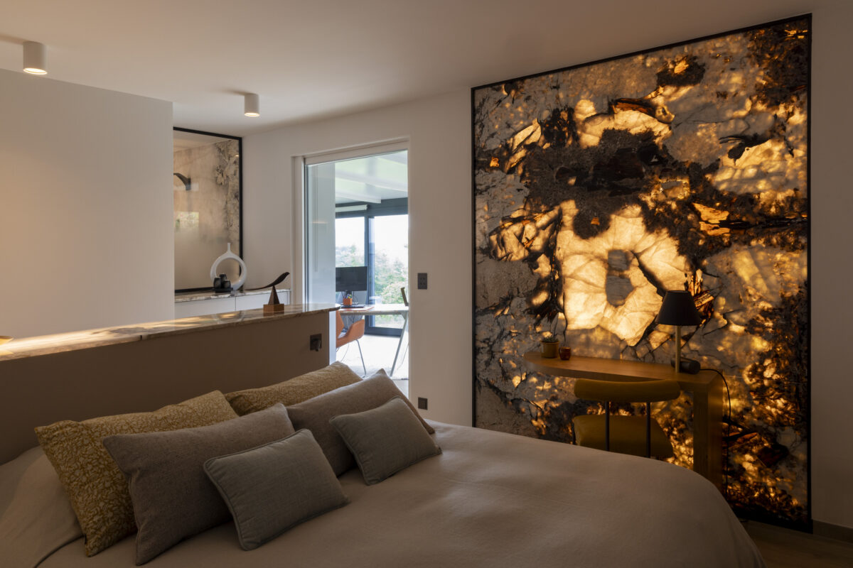 Chambre avec tête de lit en pierre rétroéclairée aux motifs dorés