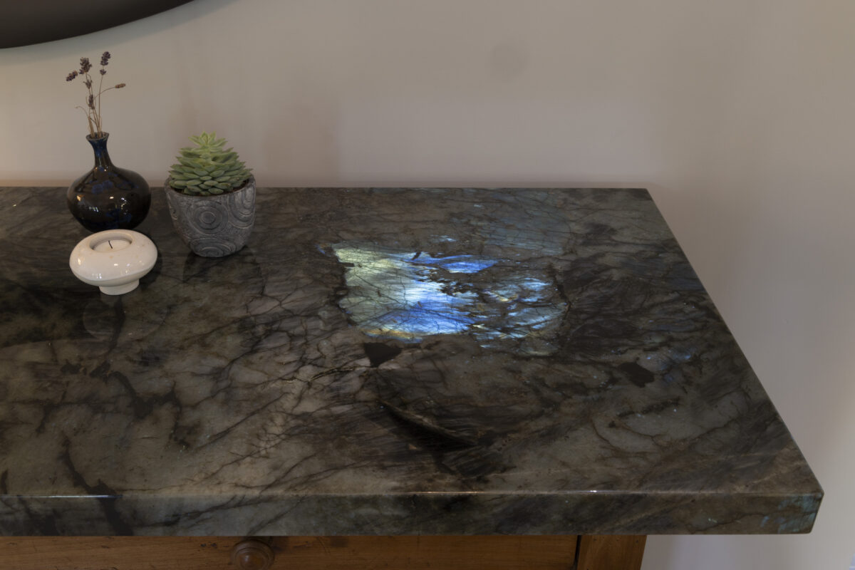 Plateau en labradorite aux reflets bleus sur un meuble en bois