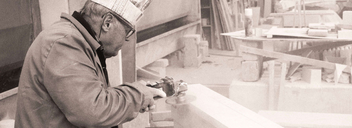 Marbrier au travail sur un bloc de pierre, photographie d’archive en noir et blanc