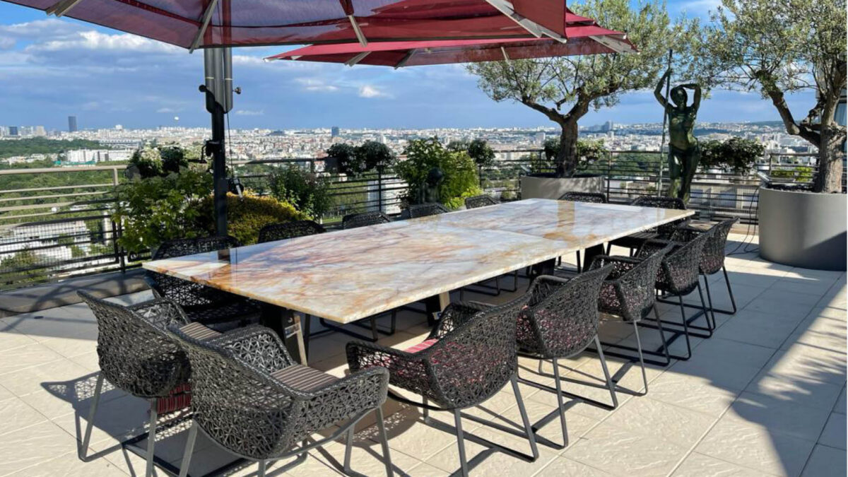 Table d'extérieur en granit Patagonia sur une terrasse avec vue sur Paris