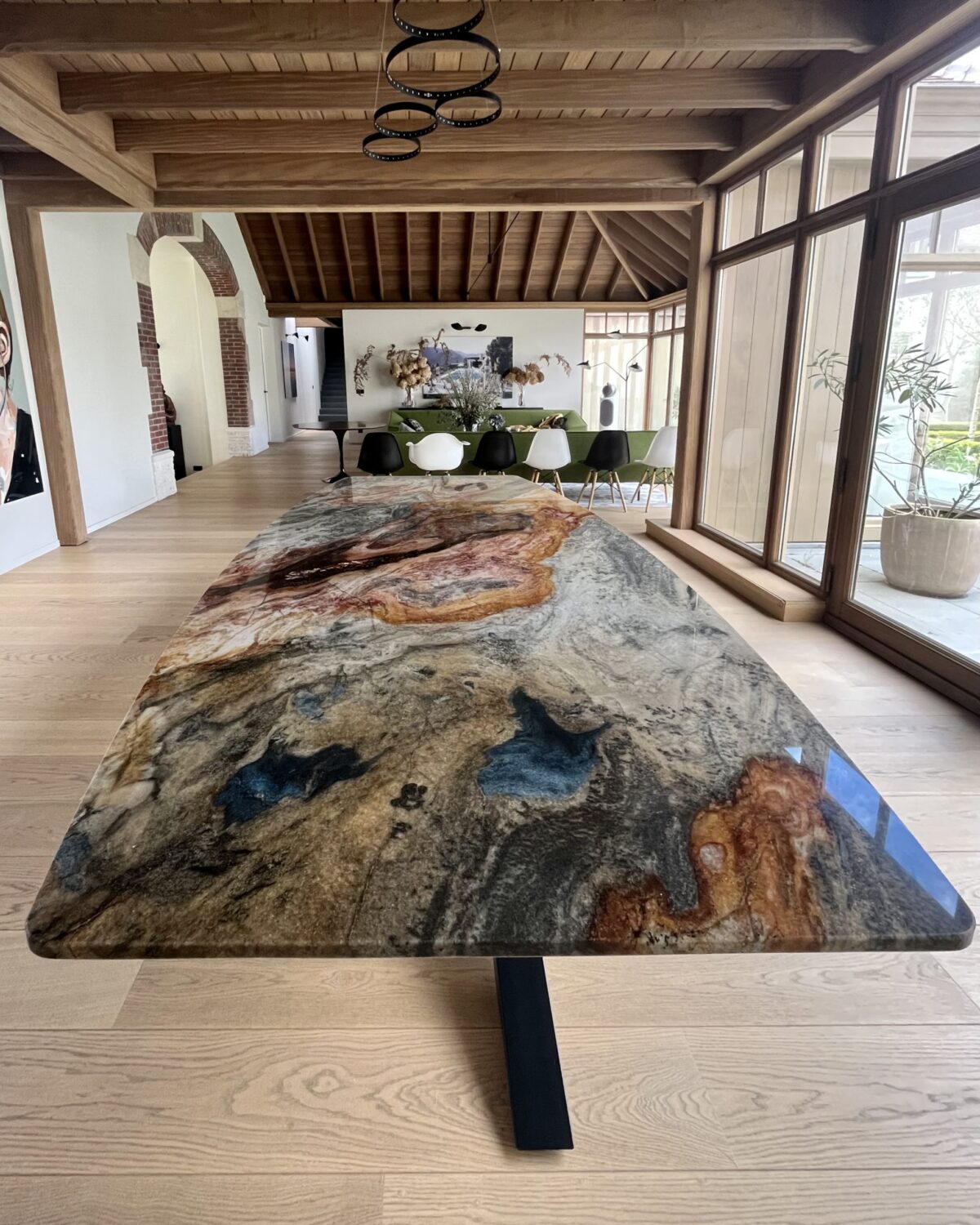 Table en quartzite Colibri Blue aux veines bleues, rouille et grises dans un séjour au plafond de bois