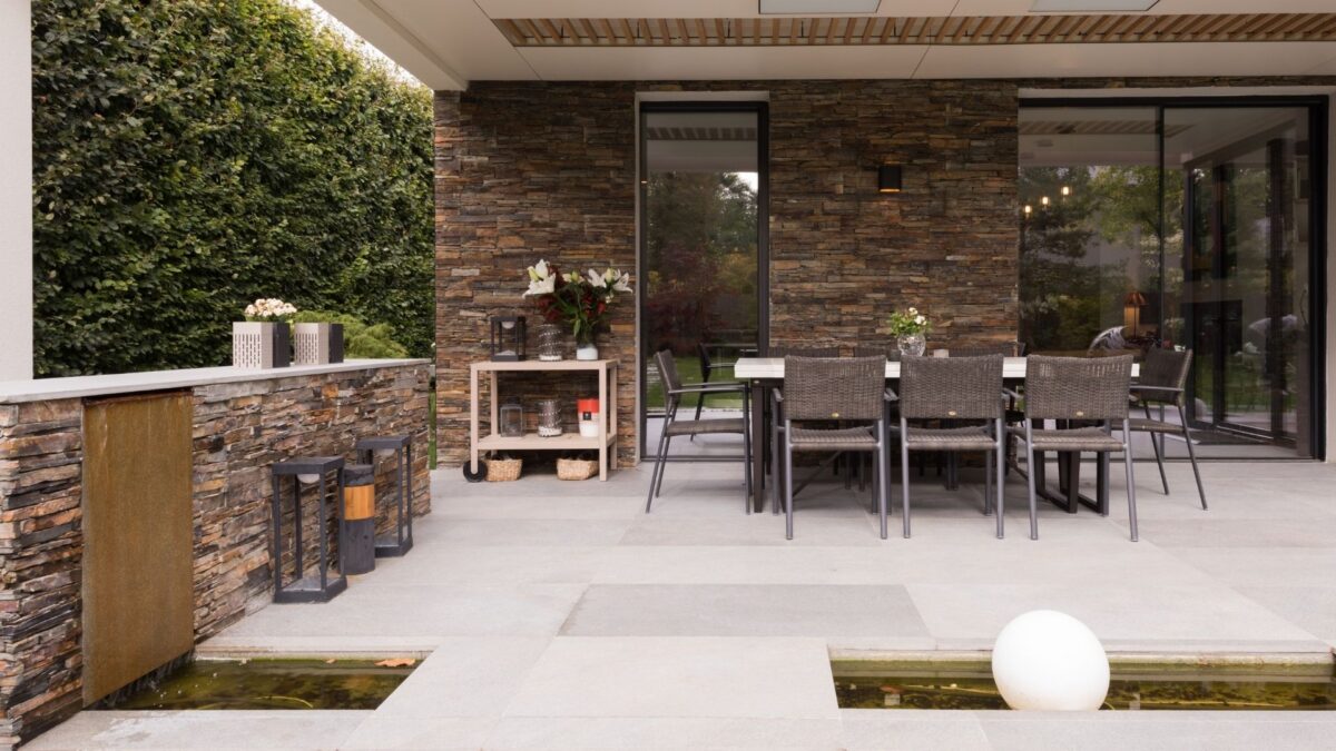 Terrasse en dalles de pierre gris bleu avec mur en pierre sèche