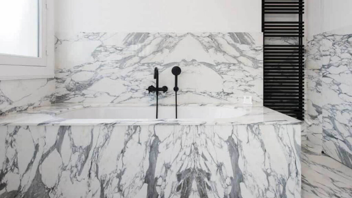 Salle de bains en marbre blanc statuaire avec robinetterie noire