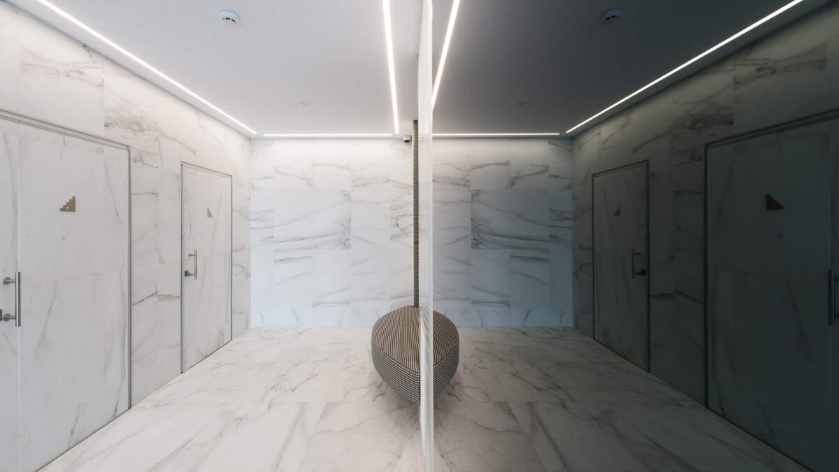 Hall habillé de marbre Calacatta au sol et aux murs, éclairage linéaire