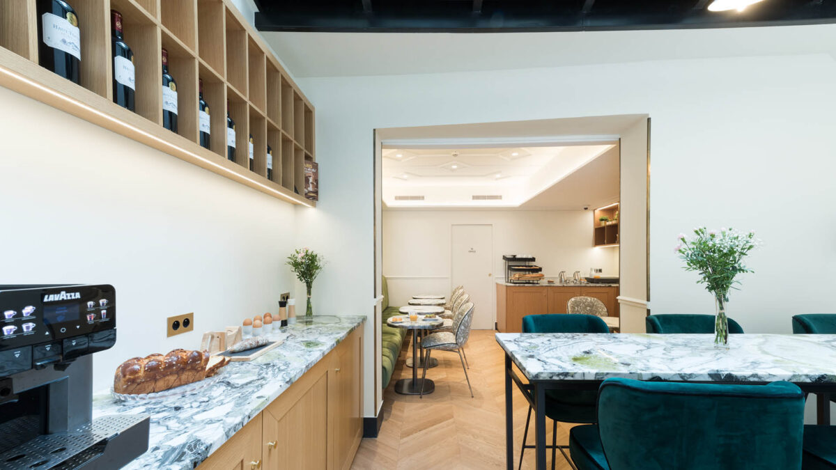 Comptoir de café en marbre veiné vert avec machine à expresso et tables assorties