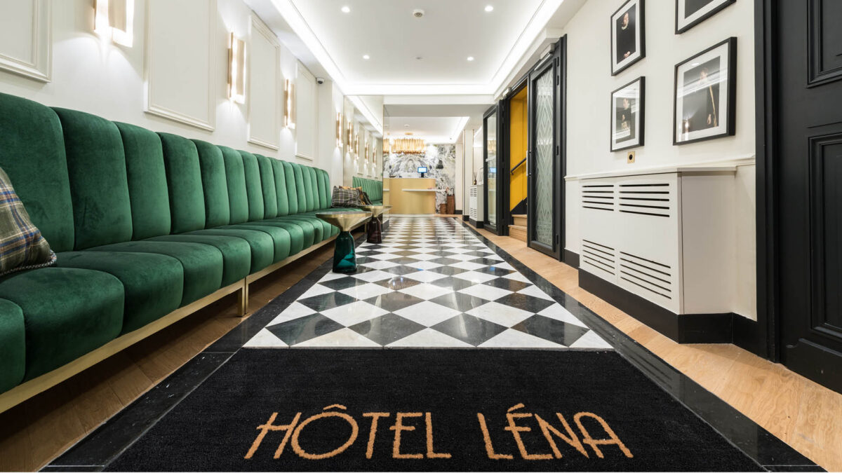 Hall de l'Hôtel Léna avec sol en damier de marbre noir et blanc et banquette de velours vert
