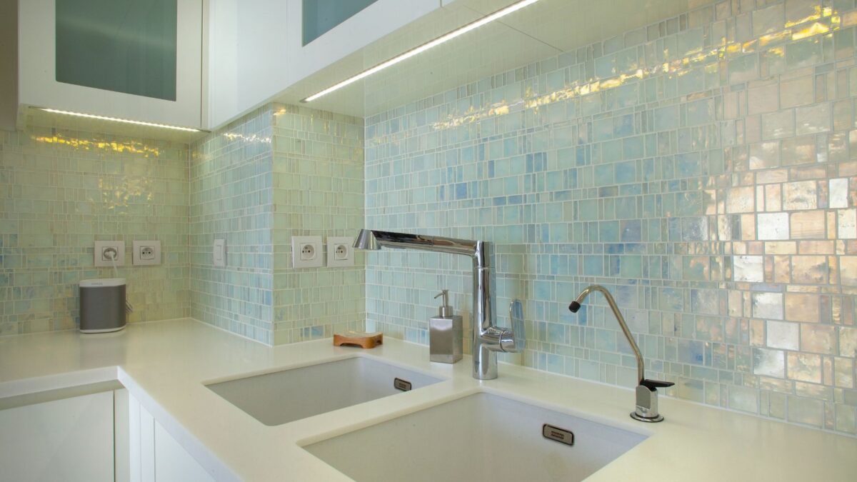 Crédence de cuisine en mosaïque de nacre irisée, double évier blanc et mitigeur chromé