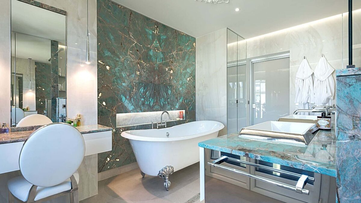 Salle de bains avec baignoire îlot, plan vasque et murs en quartzite Amazonite turquoise
