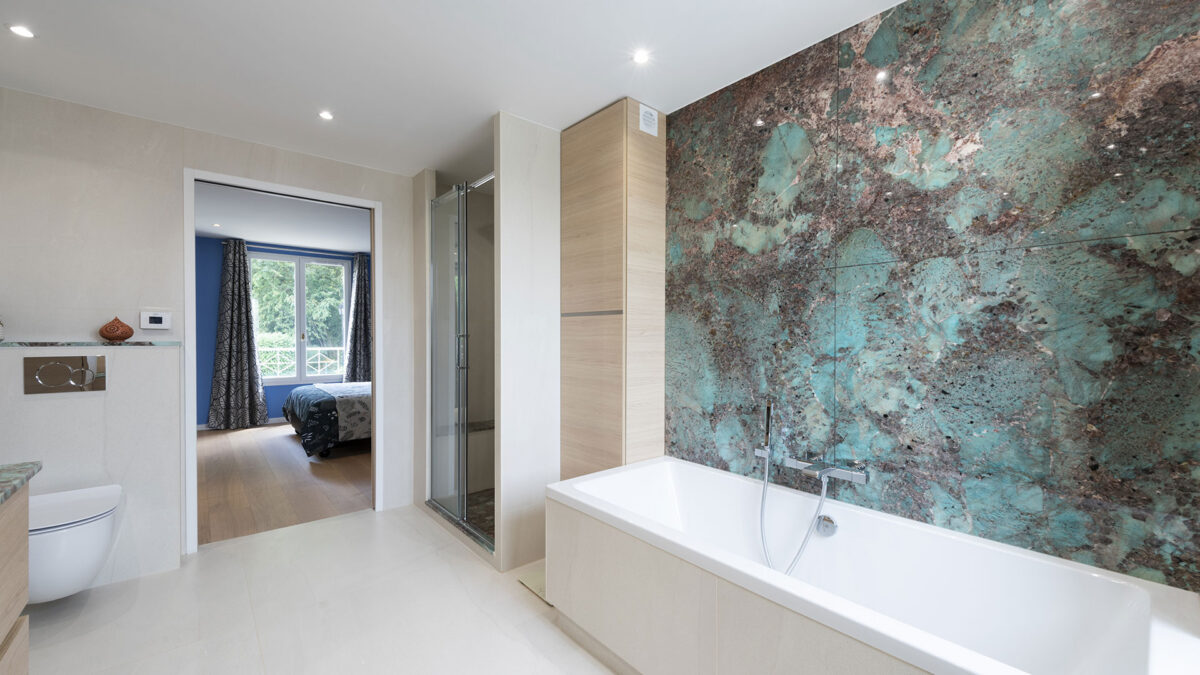 Salle de bain avec baignoire devant un mur en amazonite turquoise