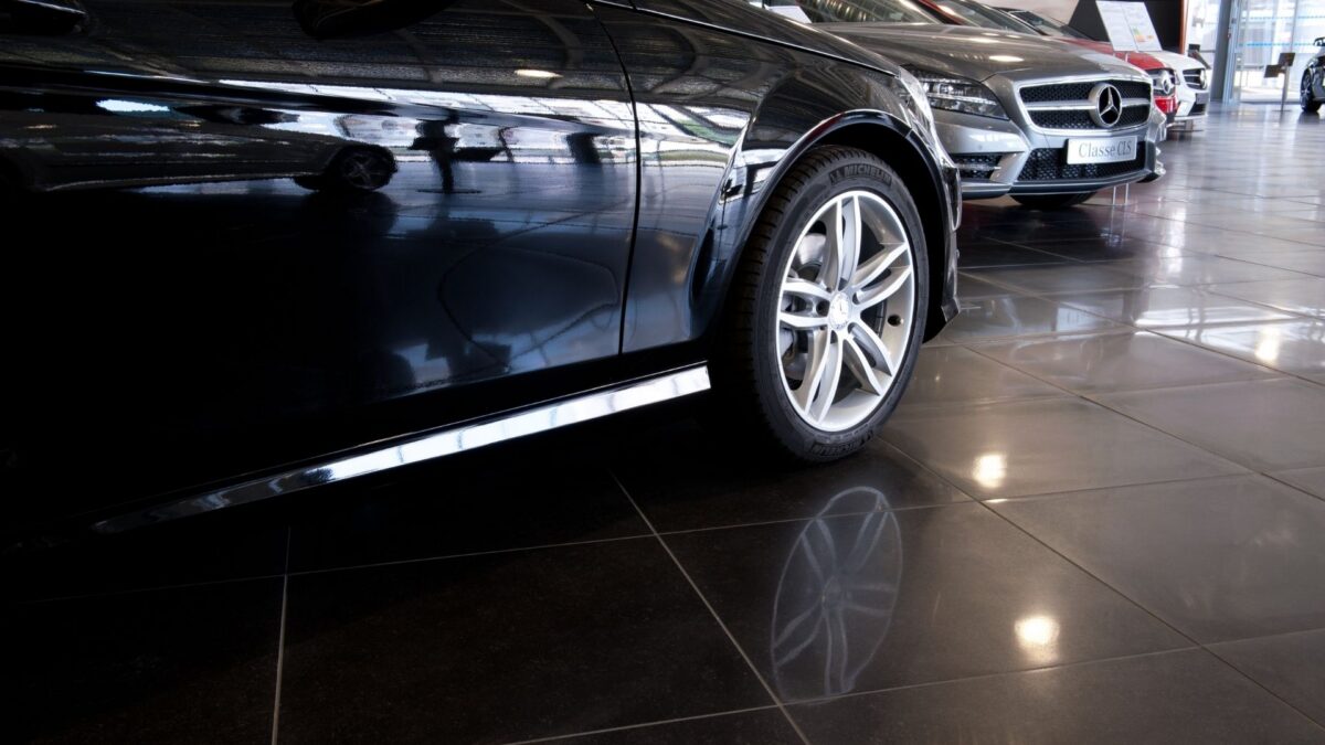 Sol en carrelage grès cérame patiné gris anthracite dans un showroom automobile