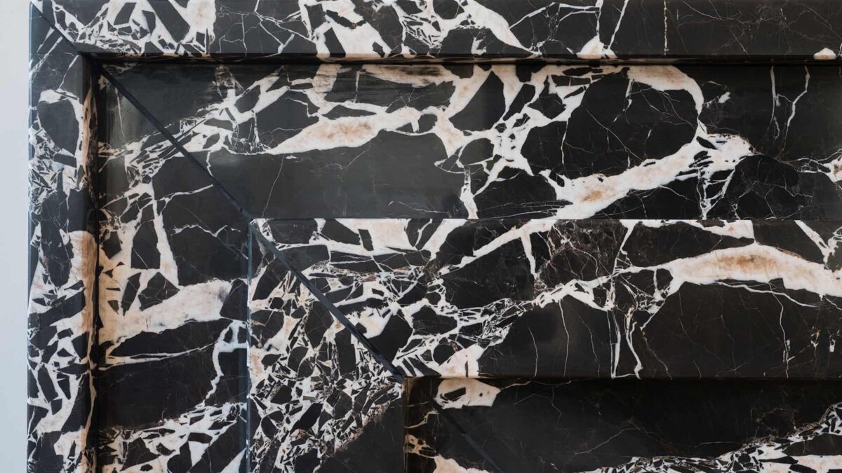 Angle d'un plan en marbre noir veiné de blanc et de rose sous un éclairage dramatique