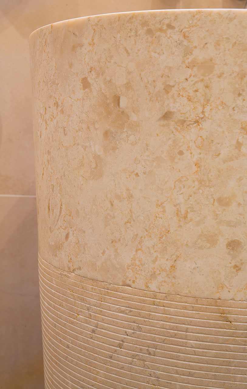 Habillage arrondi en céramique effet pierre beige à fossiles avec une partie cannelée
