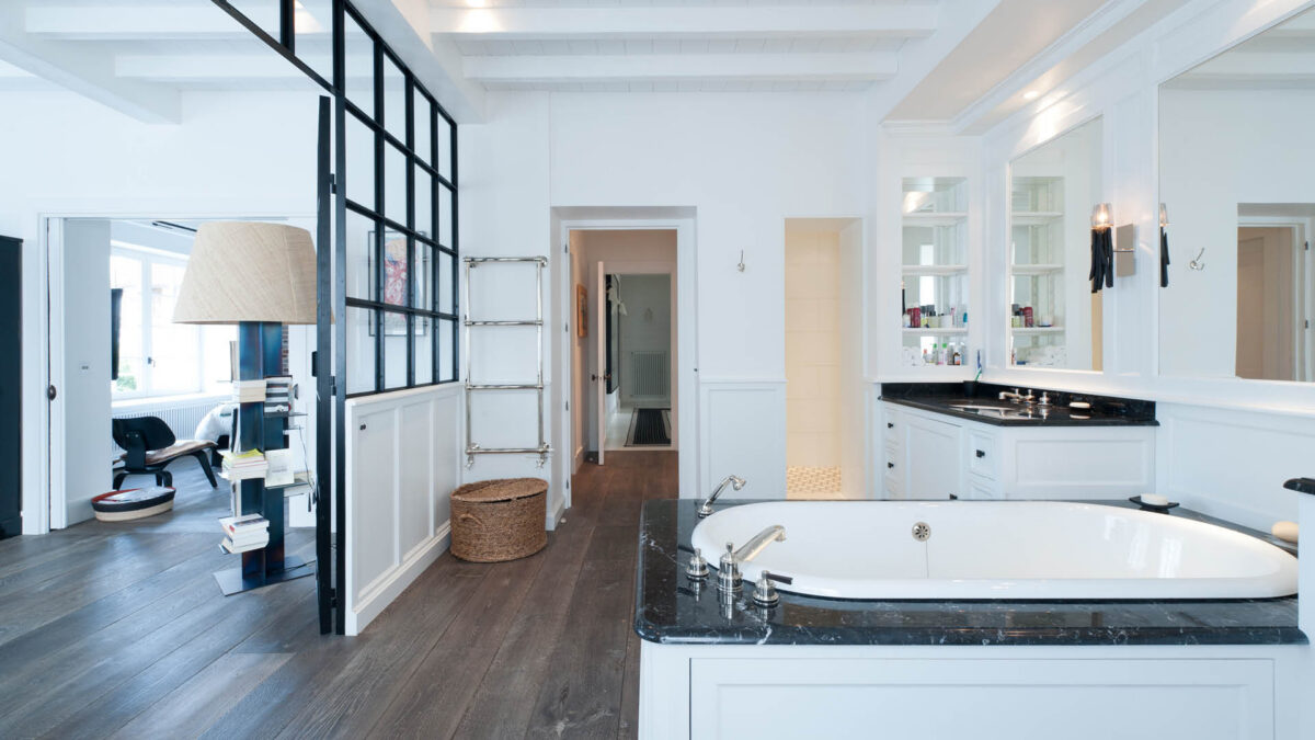 Salle de bains carrelée de blanc avec verrière noire et vasque