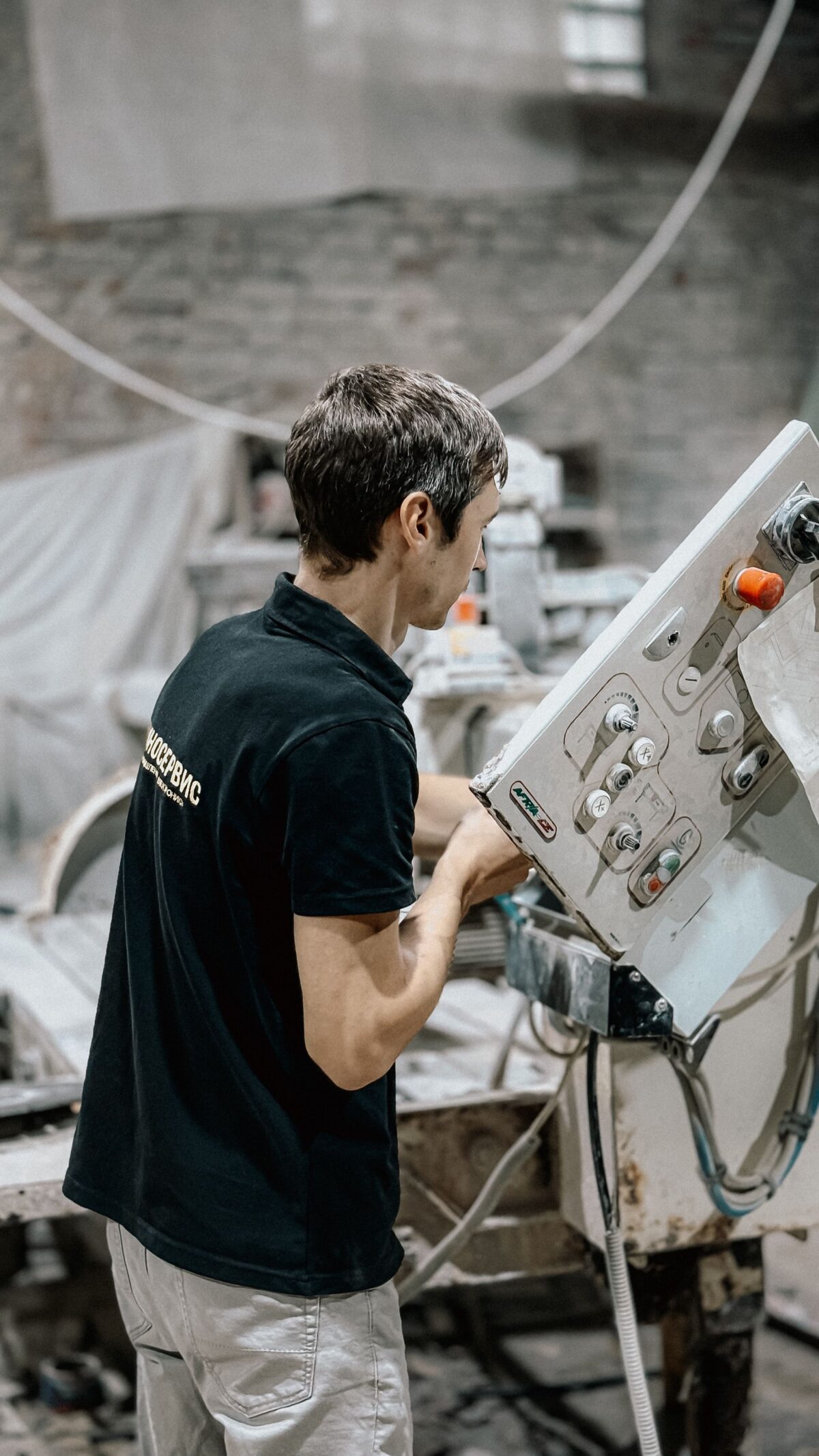 Ouvrier réglant une machine de découpe dans un atelier de marbrerie