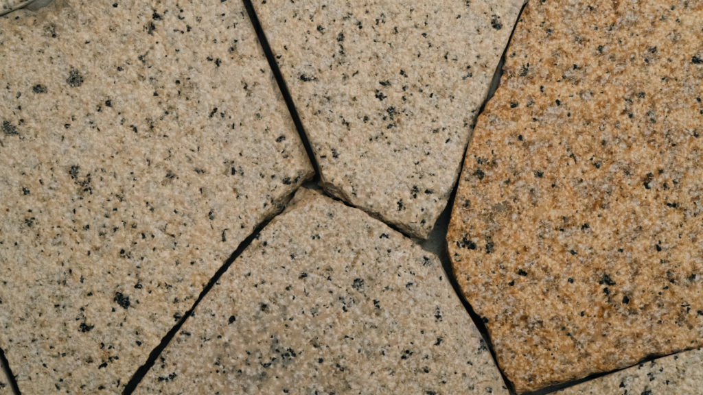 Assemblage de dalles de pierre grise et beige à grain fin avec de larges joints entre les blocs