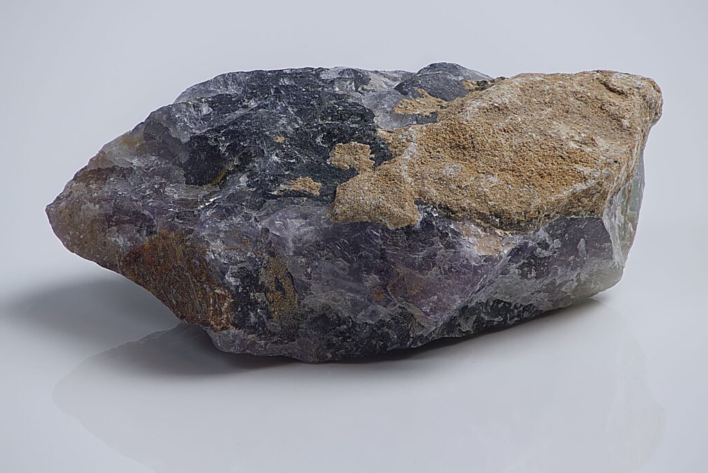 Bloc de cristal de quartz naturel brut aux facettes violettes et à la gangue dorée