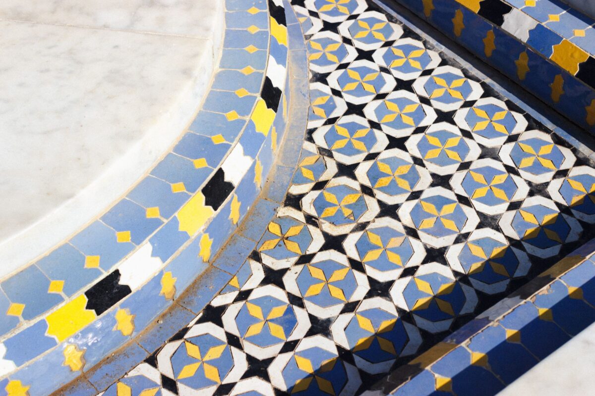 Bordure d'escalier en marbre soulignée d'une mosaïque marocaine bleue, blanche et dorée