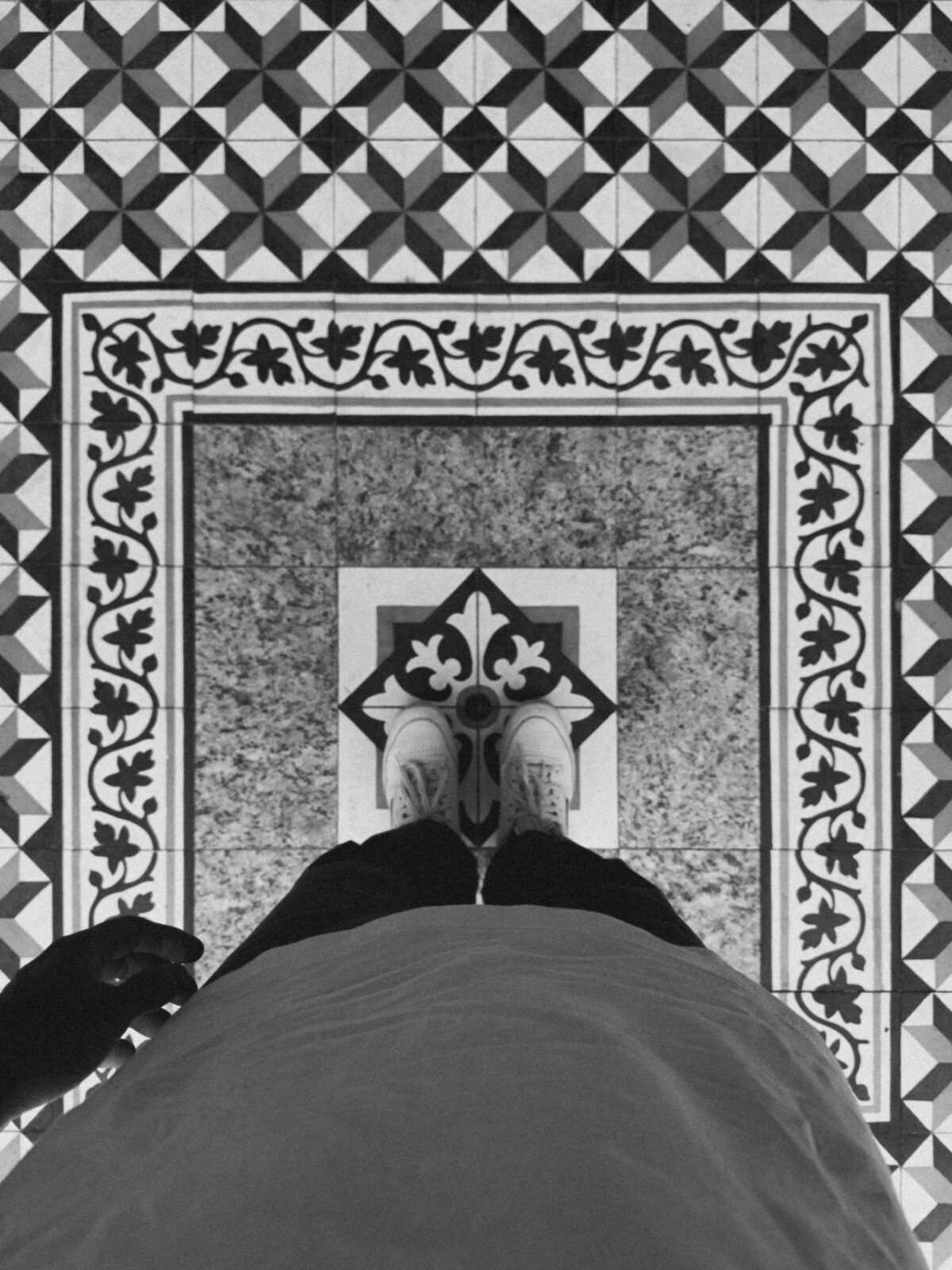 Sol ancien en carreaux de ciment à frise florale noire et blanche