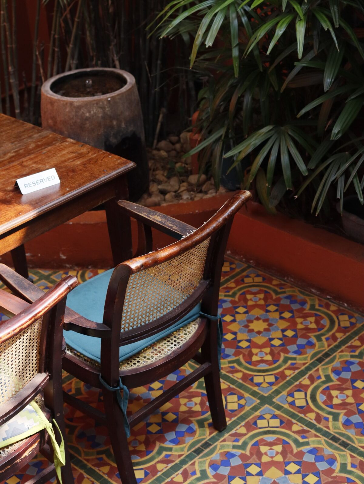 Coin café avec des chaises anciennes sur un sol en carreaux de ciment colorés