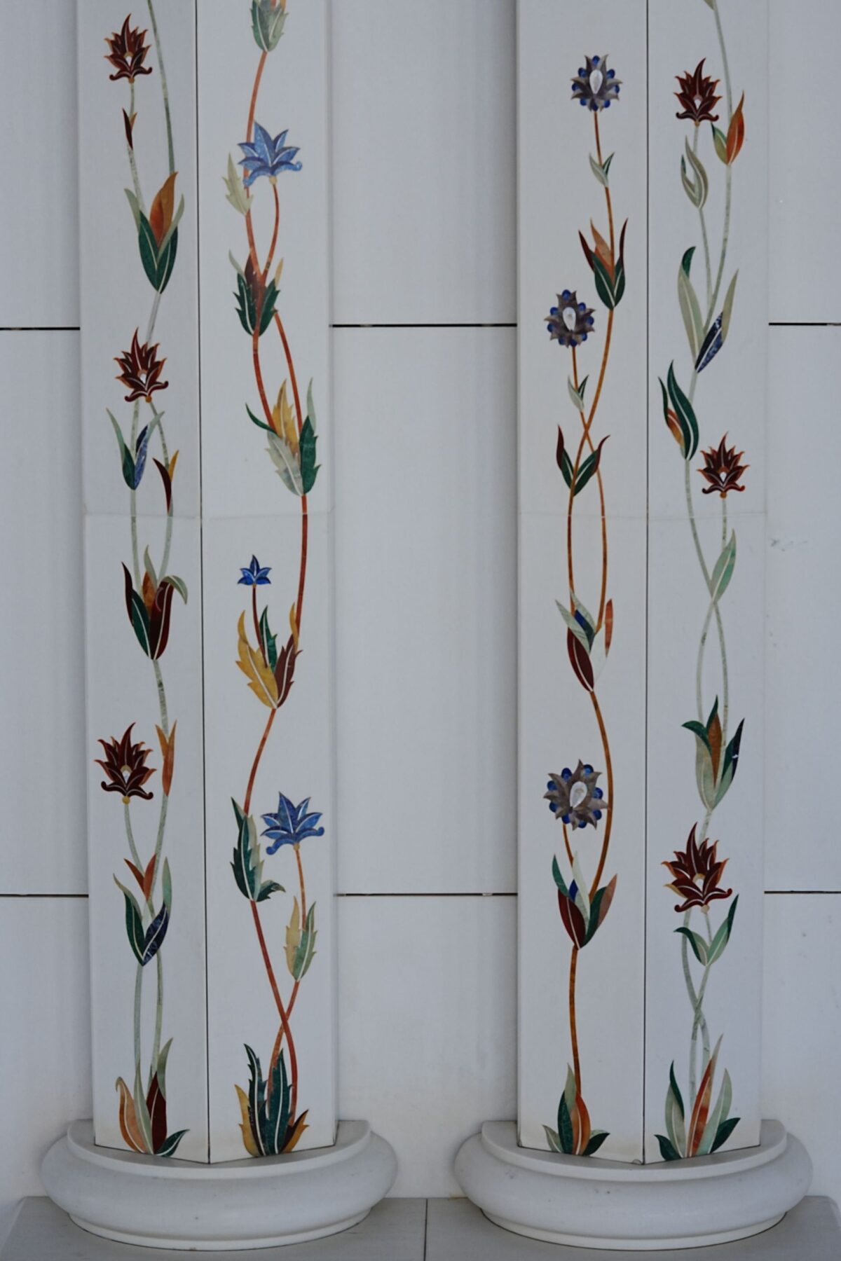 Colonnes de marbre blanc ornées d'un motif floral en marqueterie de pierres dures colorées