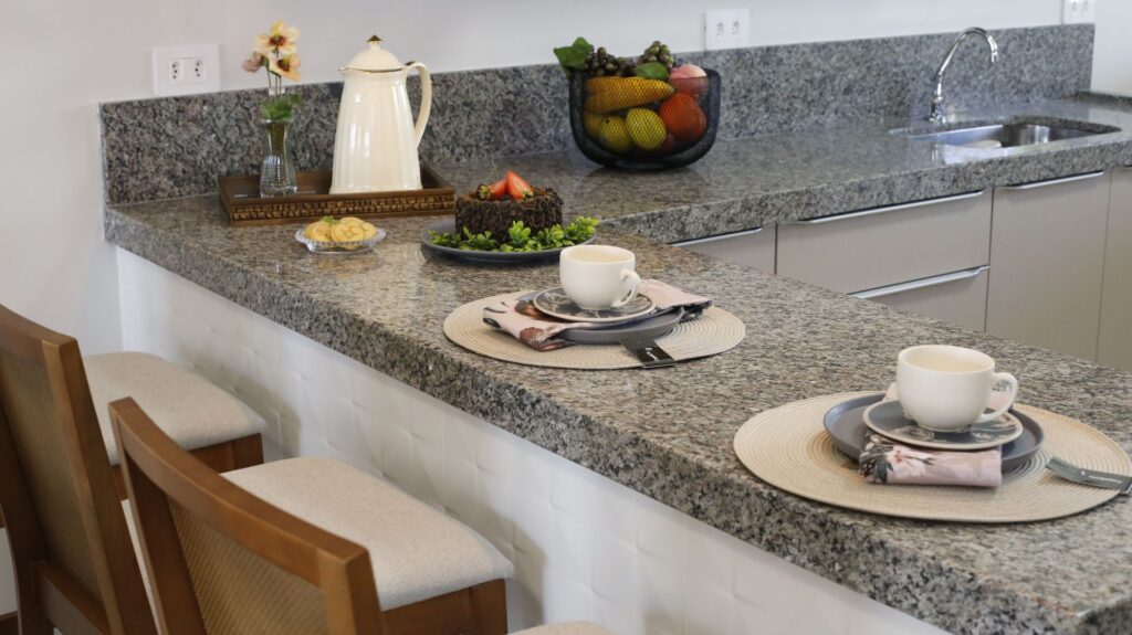 Comptoir de petit déjeuner en granit gris avec vaisselle et fleurs dressées