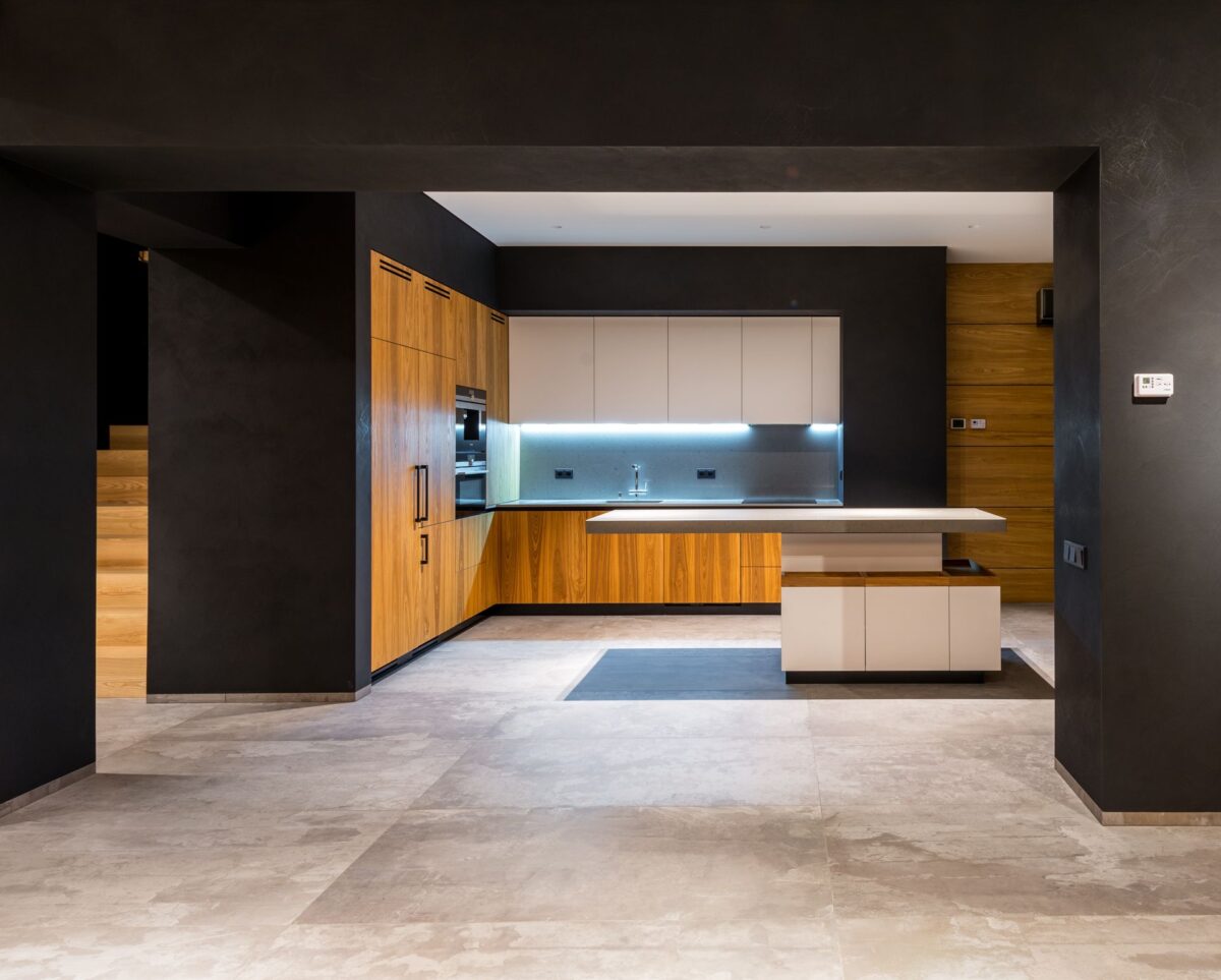 Cuisine contemporaine aux façades bois et sol clair uni de type béton ciré