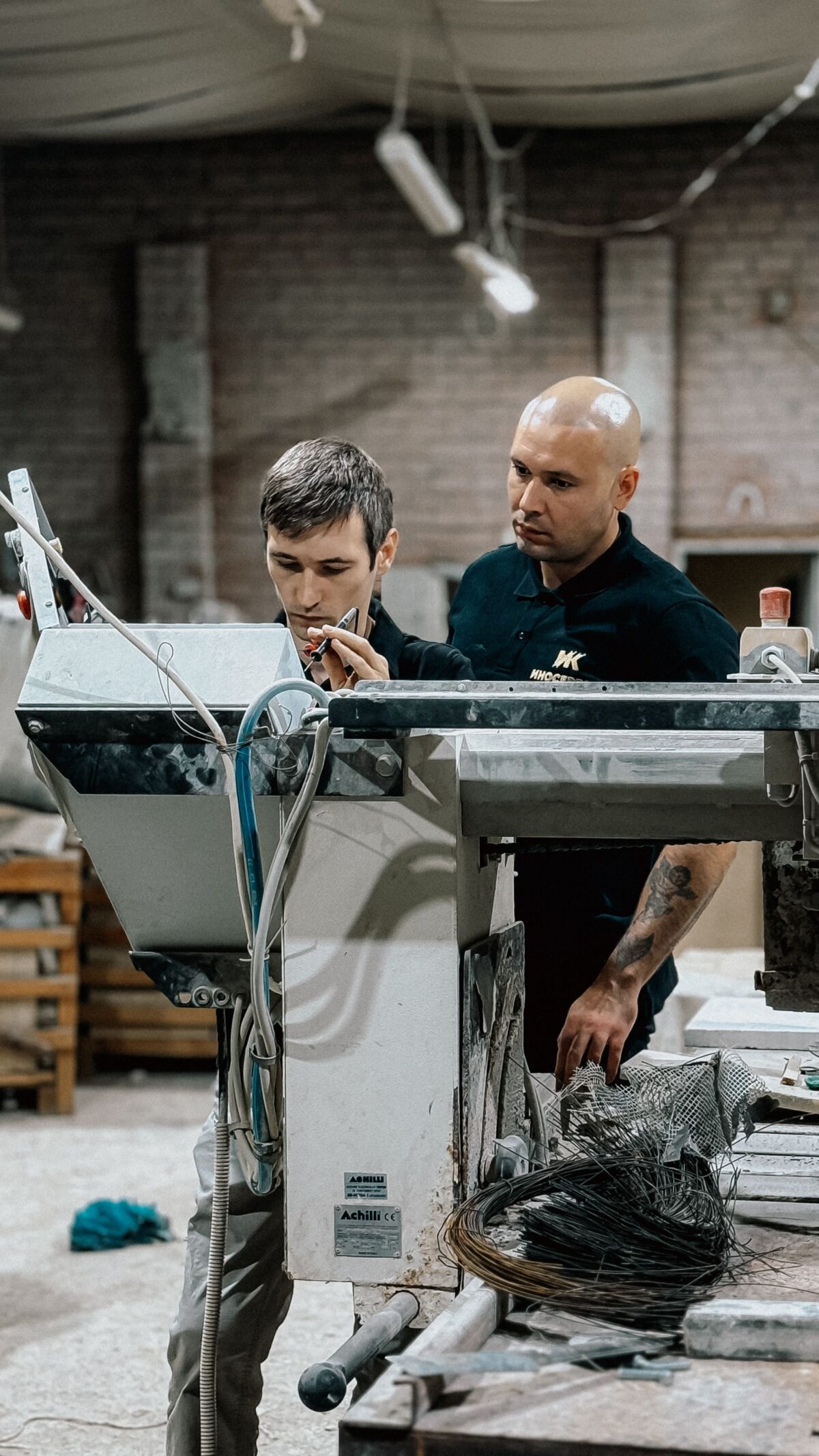 Deux artisans travaillent avec des machines dans un atelier de façonnage