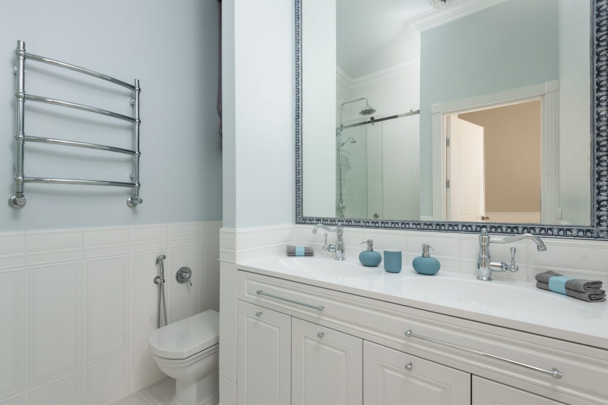 Salle de bain avec meuble double vasque blanc, miroir et robinetterie chromée