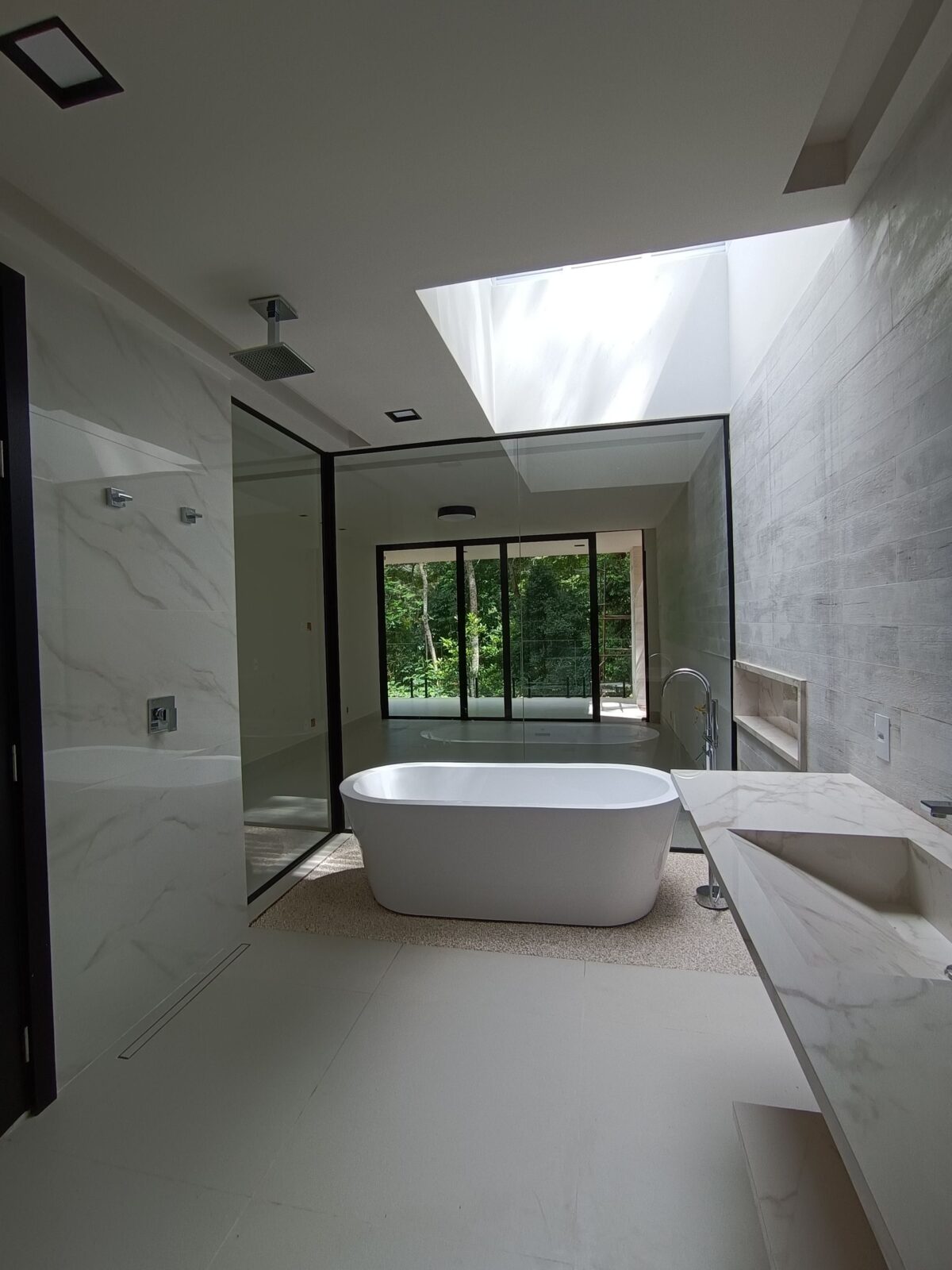 Salle de bain lumineuse avec une baignoire îlot et une grande fenêtre