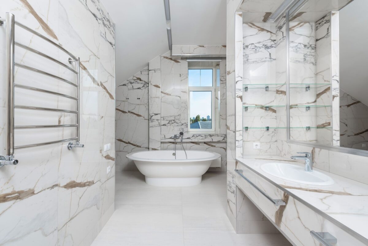 Salle de bain spacieuse en dalles claires effet marbre avec une baignoire moderne