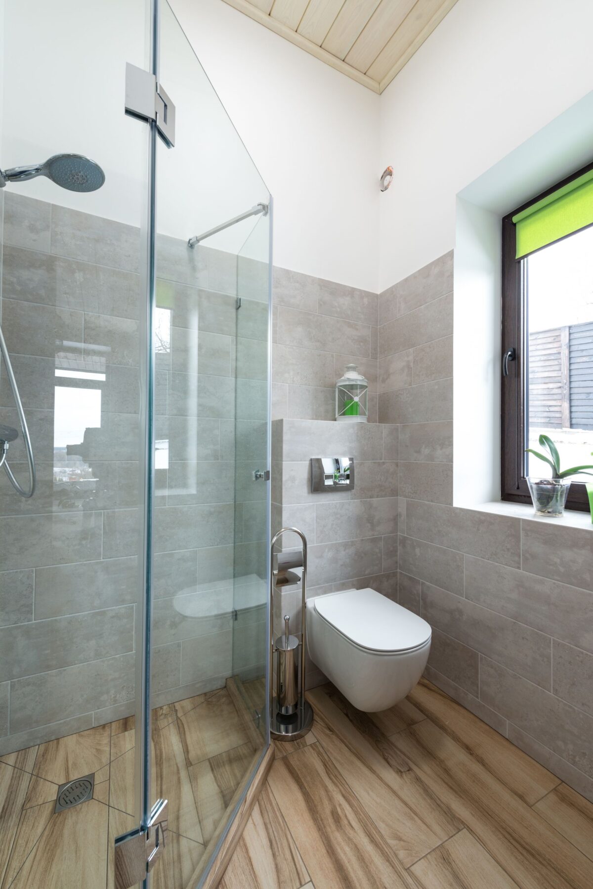 Salle de douche vitrée avec sol en carrelage imitation parquet gris