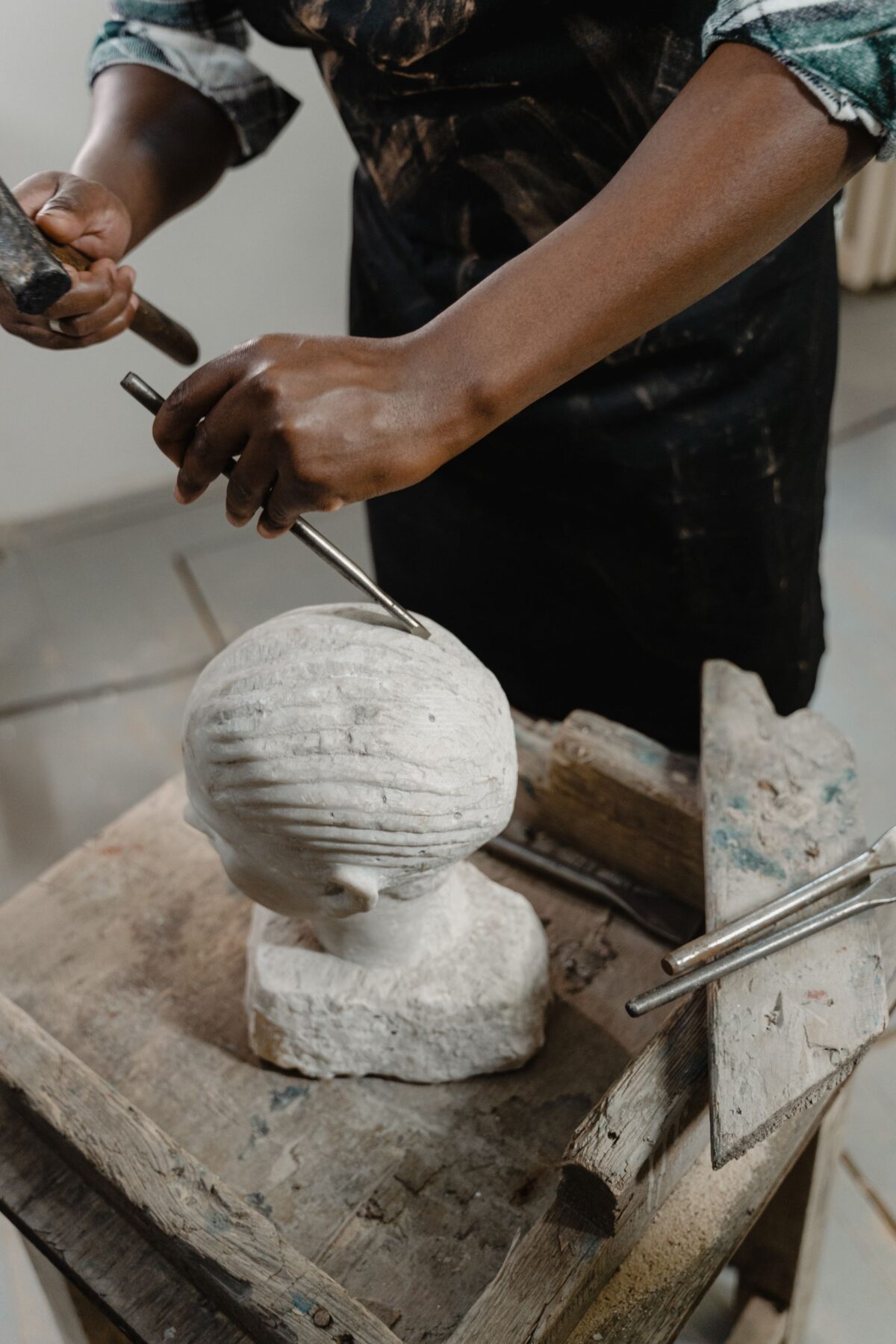 Sculpteur taillant une coquille dans un bloc de pierre blanche au ciseau