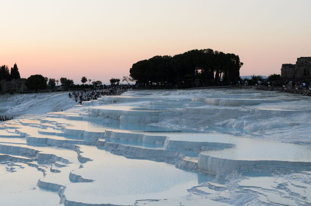 Terrasses naturelles de calcaire blanc formées par des dépôts successifs d'eau minérale, typiques de la formation du travertin