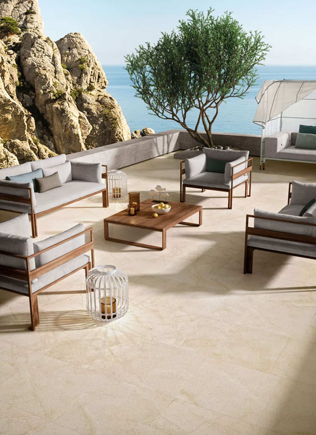 Terrasse en bord de mer au sol en carrelage aspect pierre beige
