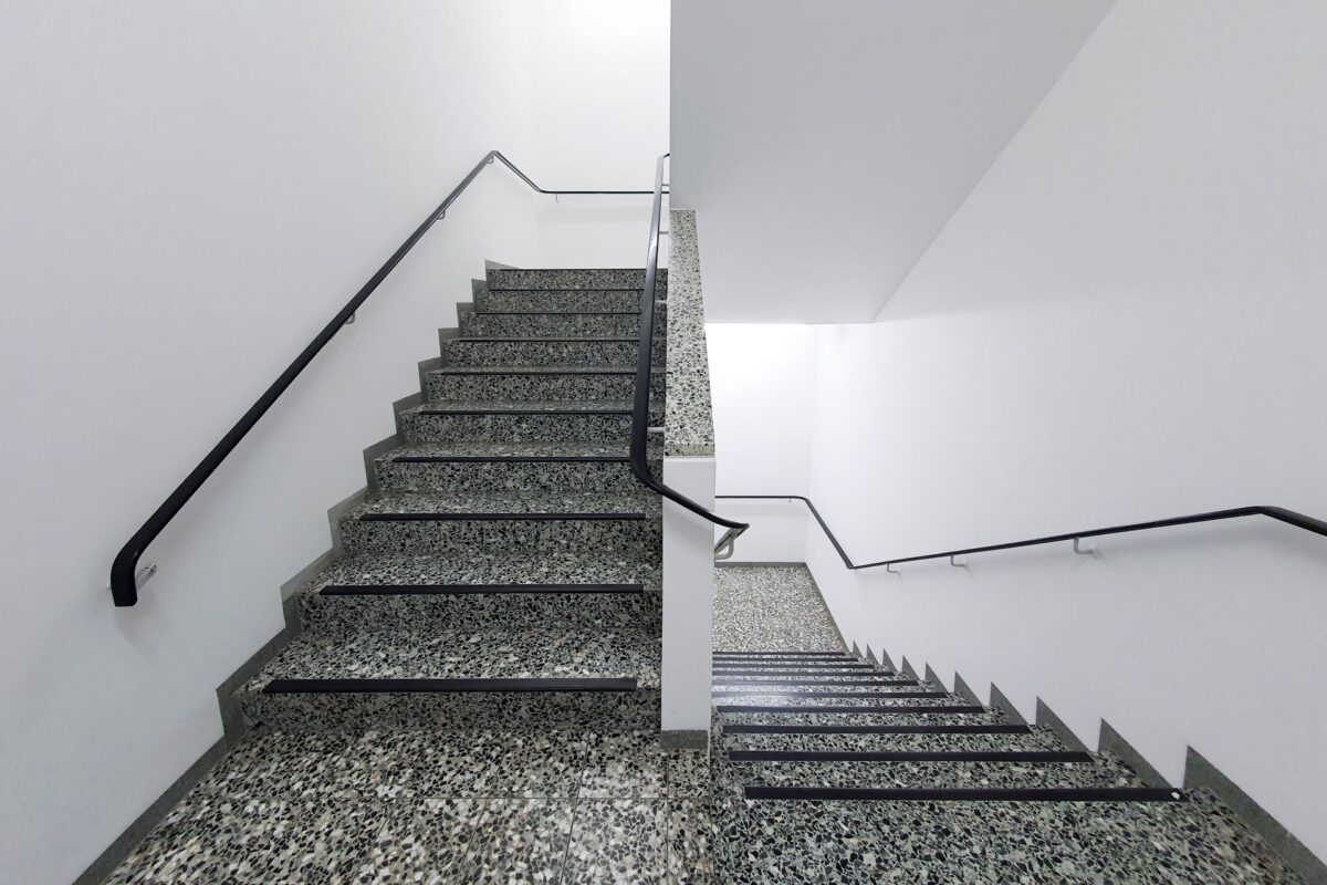 Escalier intérieur en granito gris à rampes noires