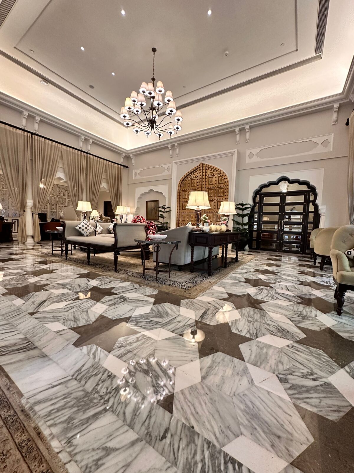 Hall d'hôtel au sol en marbre à motifs géométriques et lustre