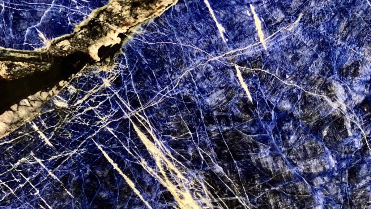Surface polie de lapis lazuli bleu outremer veinée de blanc avec une inclusion sombre