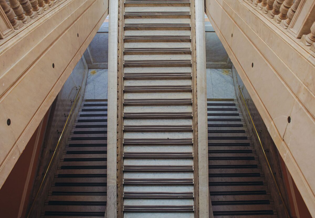Volée de marches en pierre entre deux balustrades sculptées