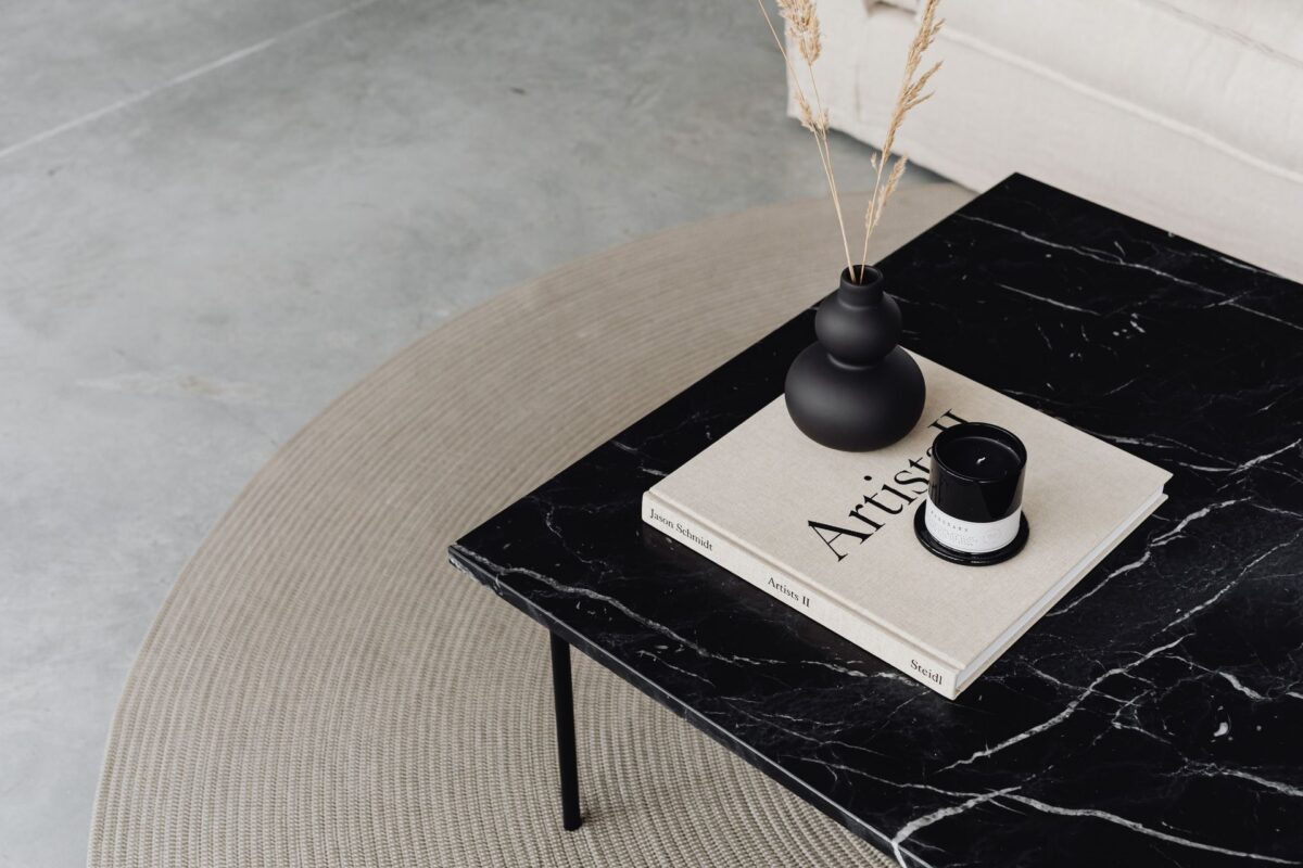 Table basse en marbre noir veiné de blanc sur piètement fin dans un salon minimaliste