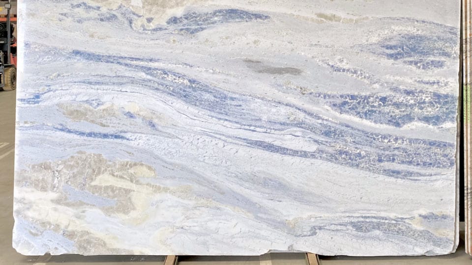 Tranche de marbre Iceberg bleu avec inclusions de calcite bleue, posée sur chevalet dans l'entrepôt