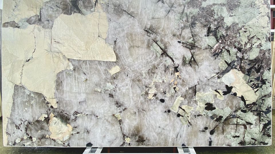 Tranche de granit Patagonia de 330 x 200 cm pleine d'inclusions de cristal de roche, posée sur chevalet